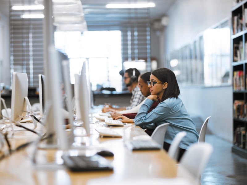 Profesionales trabajando en oficina con ordenadores de sobremesa en entorno corporativo TI